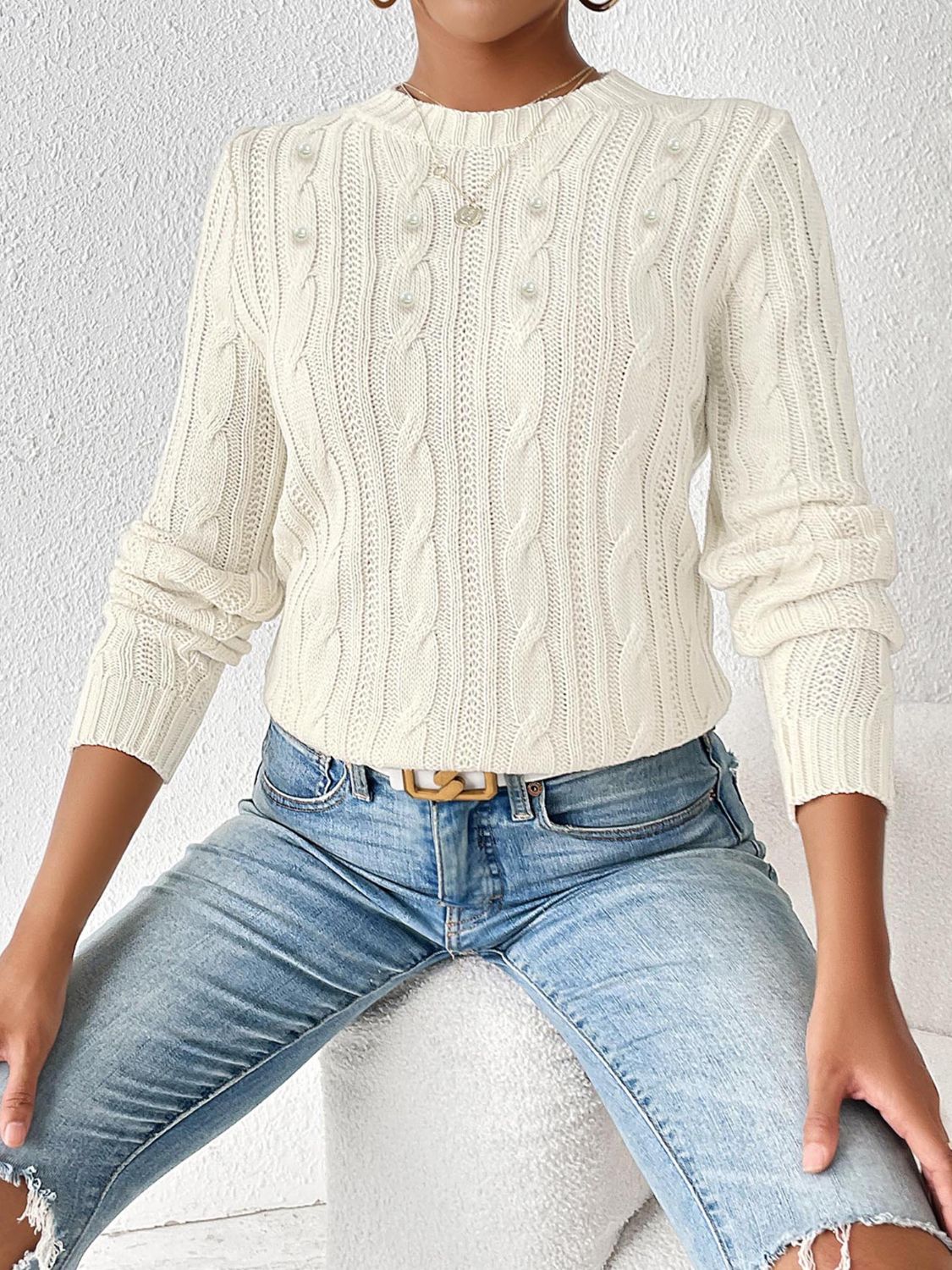Pull élégant avec des motifs tissés et de délicats détails de perles